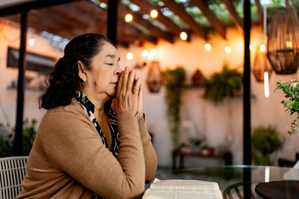 Senior woman praying at home