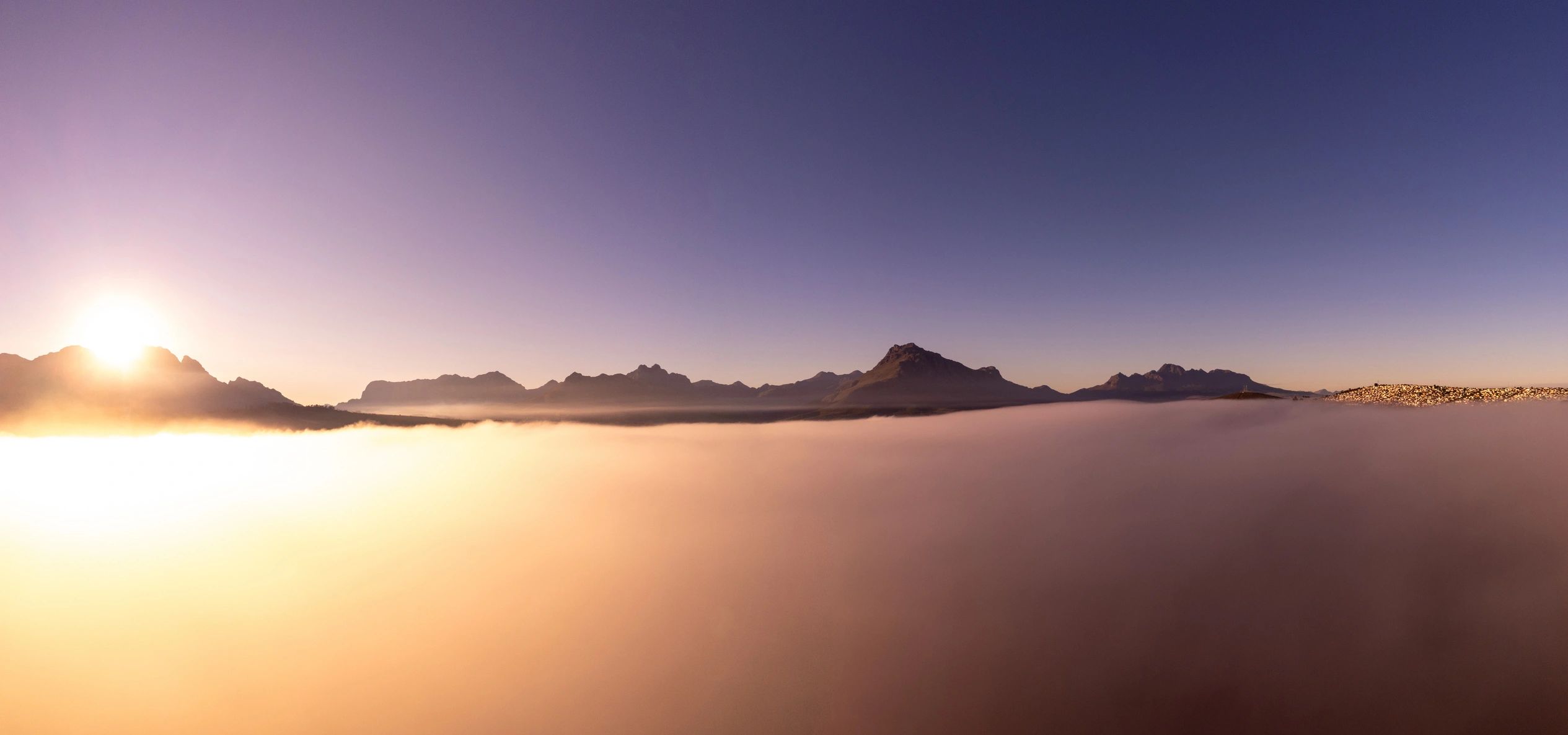 Aerial sunrise view of foggy Stellenbosch mountains with a calm atmosphere