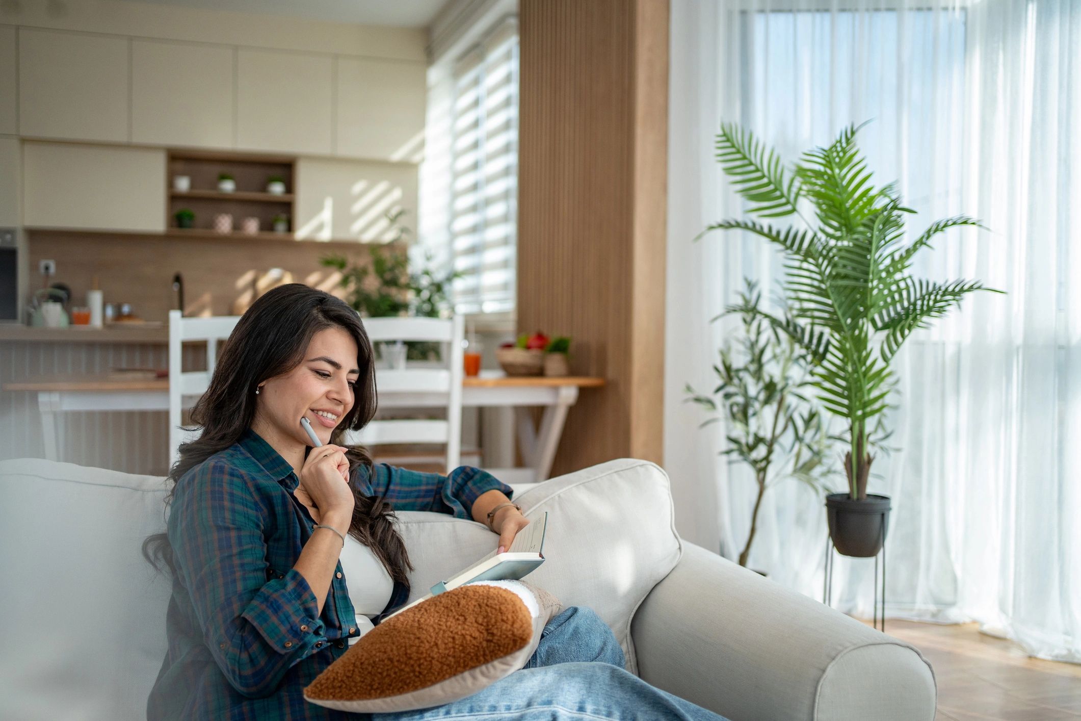 Woman journaling at home, reflecting in a calm moment