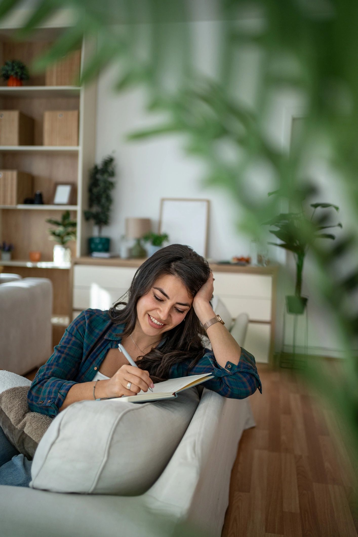 Woman journaling on a couch in a calm, reflective moment